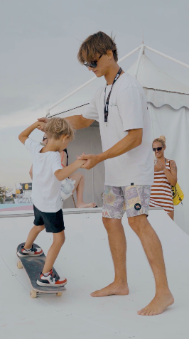 Un adulto accompagna un bambino sullo skateboard